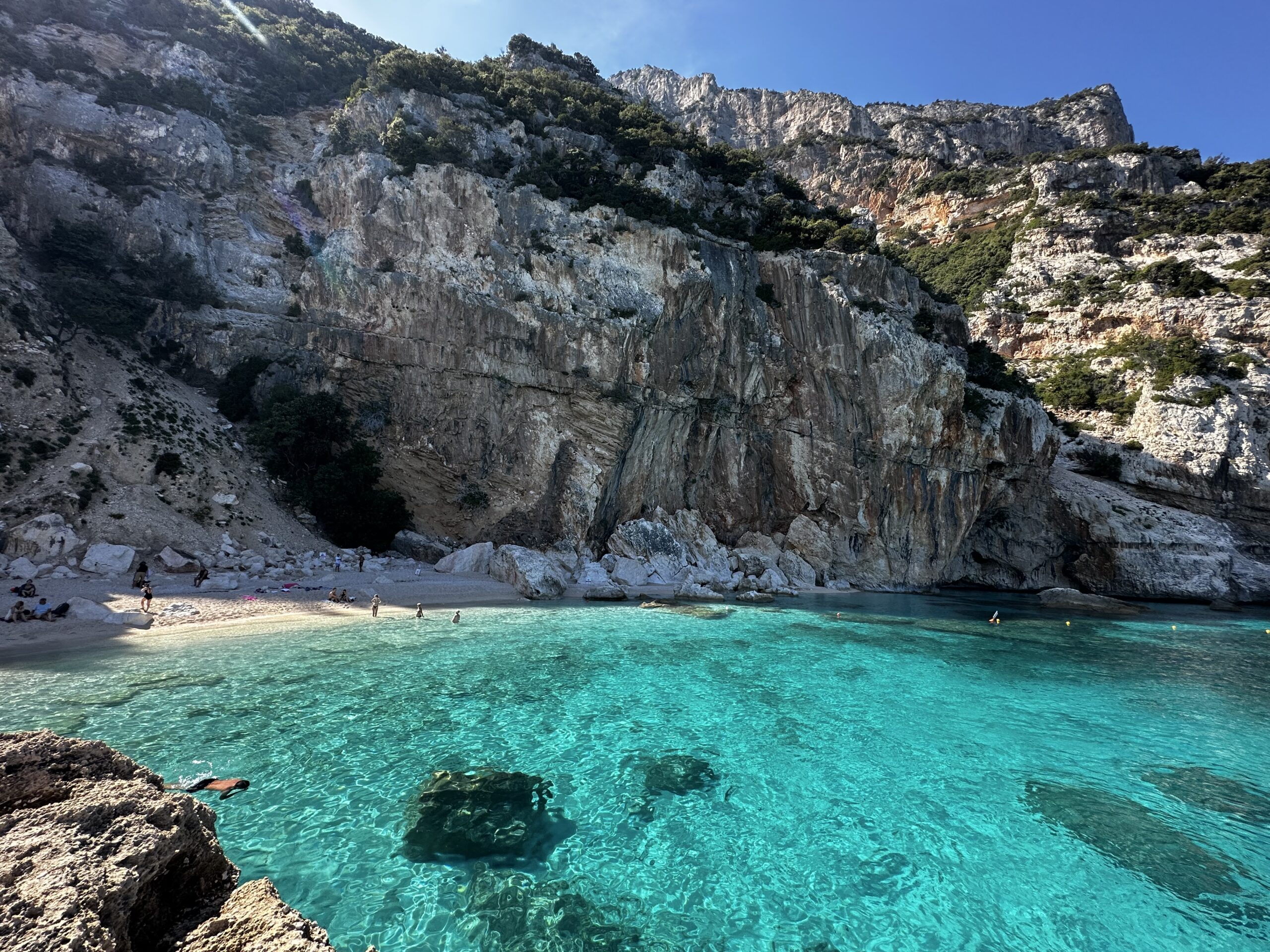 4 - Cala Mariolu, situata sulla costa est della Sardegna, è una delle spiagge più suggestive del Golfo di Orosei. Con sabbia bianca, ciottoli tondi e acque cristalline, è ideale per il nuoto e lo snorkeling. Circondata da scogliere e vegetazione, offre un'atmosfera tranquilla e incontaminata, accessibile via mare o a piedi.